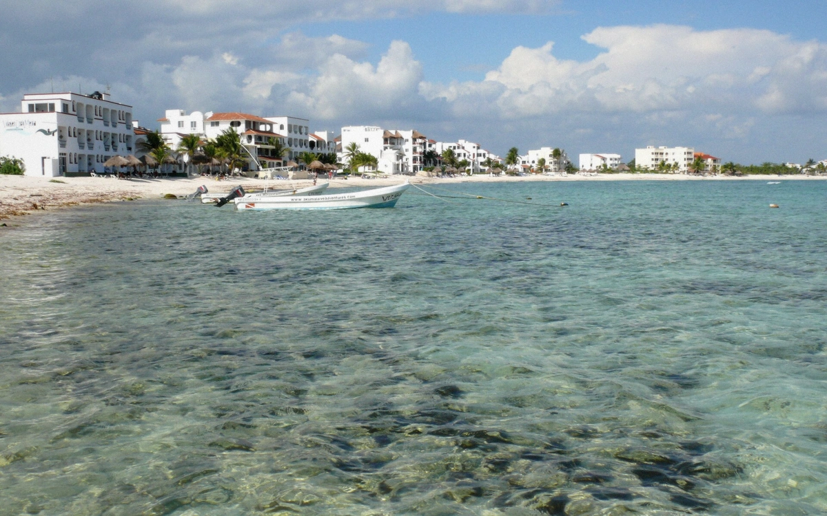 Rocky half moon shaped cove with calm turquoise water and low rocks at Akumal, Mexico
