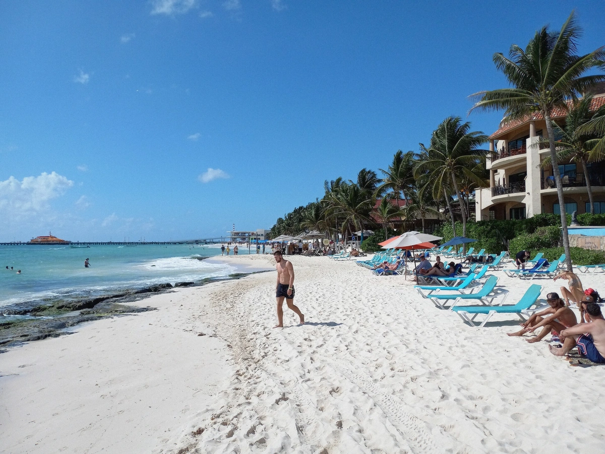 Wide beach with white sand and palm trees at Playa del Carmen, Mexico